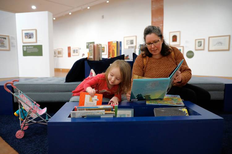 Sarah Nelson of Amherst and Audrey, 4, look through picture books at “Alphabet Soup: How Picture Books Are Made, From A to Z” at the Eric Carle Museum of Picture Book Art.