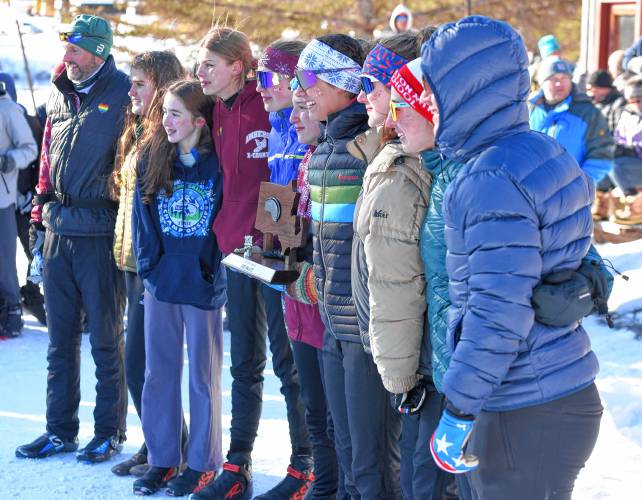 The Amherst girls team shows off its runner-up trophy after finishing in second place at the MIAA Nordic Ski Championships at Prospect Mountain in Woodford, Vt. on Wednesday.