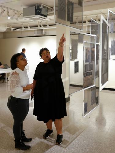 Adrienne Chadwick, right, talks with Kandy G Lopez about Chadwick’s installation, “For Descendants Yet To Come,” at the Augusta Savage Gallery at UMass Amherst.