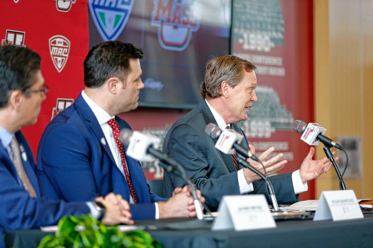 MAC commissioner Dr. Jon Steinbrecher, right, speaks along with Director of Athletics Ryan Bamford and Chancellor Javier Reyes during a press conference at the Martin Jacobson Football Performance Center on Thursday regarding the University of Massachusetts joining the Mid-American Conference.