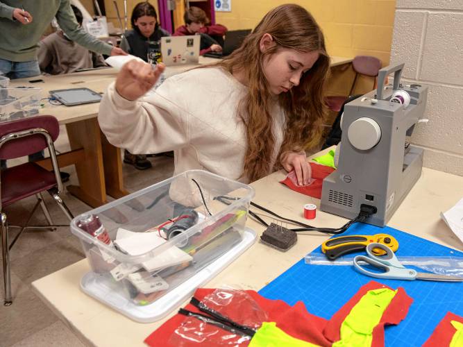 Amherst High student Libby Smith works on creating a waterproof pocket for the chip that is part of the InvenTeam’s project.
