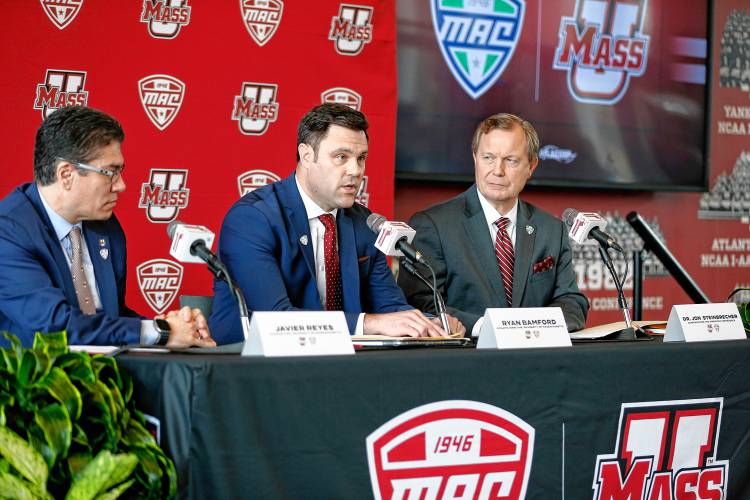 Director of Athletics Ryan Bamford, center, speaks along with MAC commissioner Dr. Jon Steinbrecher, right, and Chancellor Javier Reyes during a press conference at the Martin Jacobson Football Performance Center on Thursday regarding the University of Massachusetts joining the Mid-American Conference.